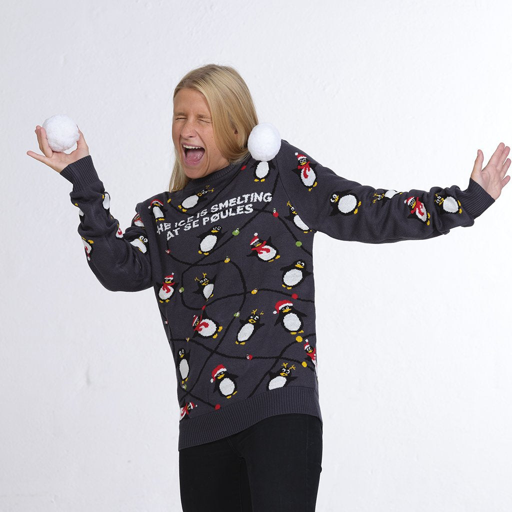 Una donna che indossa un maglione natalizio grigio con pinguini.